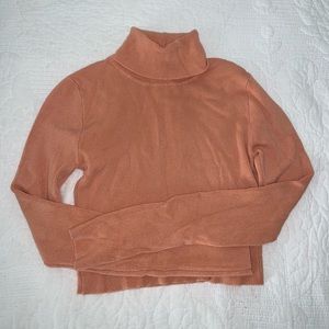 Peach colored cropped long sleeve turtle neck.